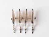 three silver plated spoons are lined up on a white surface