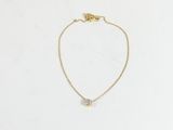 un collier en or orné d'un petit diamant blanc, monté sur une chaîne en or