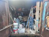 an open door to a storage area with paint and other items