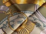 a close up of a scarf with a gold and green design