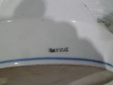 a close up of a white plate with a blue stripe