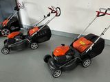 several lawn mowers are lined up in a row in a room