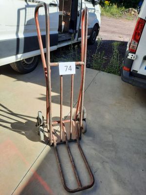 a luggage cart with a number on it in front of a van