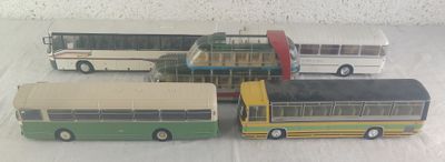 six petits bus en jouet posés sur une table
