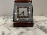 a small clock sitting on top of a marble table