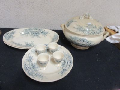a blue and white dinner set on a black table