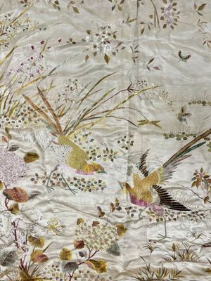 deux oiseaux qui volent dans les airs près de quelques fleurs