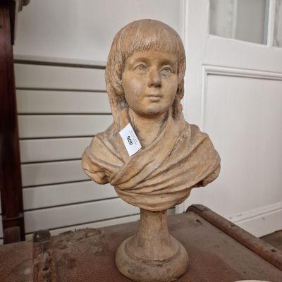 une statue représentant une femme portant un foulard, posée sur une table