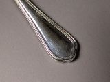 a silver spoon with a long handle on a table