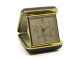 une petite horloge carrée posée sur une table