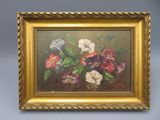 une peinture à l'huile représentant des fleurs, dans un cadre doré, accrochée à un mur bleu
