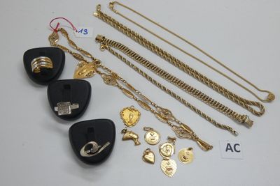 plusieurs bijoux dorés et noirs, notamment un médiator, un collier, un bracelet et une bague