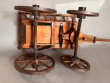 an old fashioned wooden machine with wheels on a table
