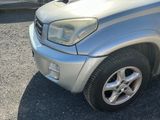 a silver suv parked in a lot with other cars in the background