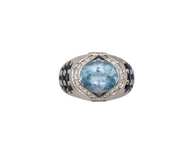 gros plan d'une bague avec une pierre bleue entourée de diamants