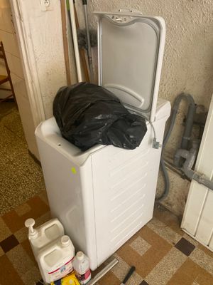 une photo d'une machine à laver sur laquelle est posé un sac poubelle