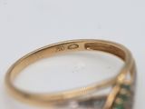 a close up of a gold ring with a green stone