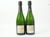 deux bouteilles de vin posées l'une à côté de l'autre sur une surface blanche