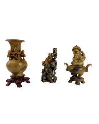 trois figurines en bronze représentant un homme et une femme, posées sur un socle