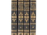 three books are lined up in a row on a white surface