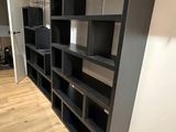 a black book shelf in the corner of a room