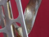 une sculpture métallique représentant un oiseau tenant une fourchette dans son bec
