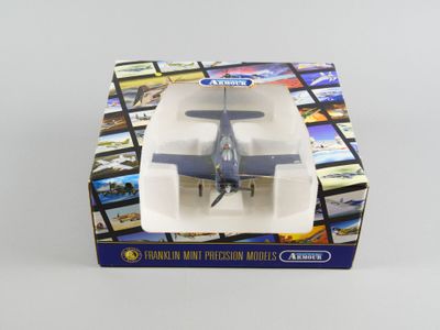 un petit avion en jouet qui se trouve dans une boîte posée sur une table