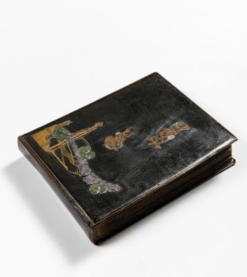 an old book with a painting on it sitting on a white surface