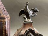 a statue of a bird on top of a clock