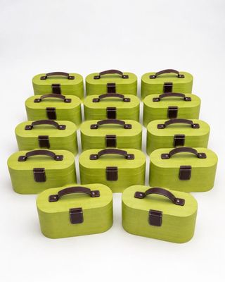 Plusieurs valises vertes sont disposées en cercle sur une surface blanche