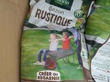 two bags of grass sit in a cardboard box on a table