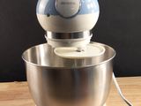 a blue and white mixer sitting on a wooden table