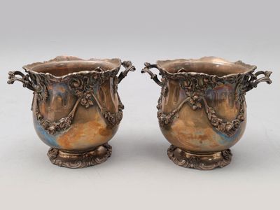 paire de vases en argent munis d'anses et de poignées, posés sur des socles