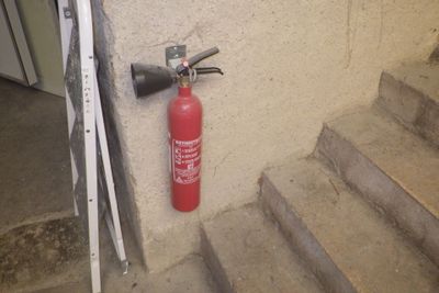 un extincteur accroché au mur à côté de l'escalier