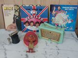 une table sur laquelle se trouvent divers objets, notamment une radio, un tourne-disque et d'autres objets
