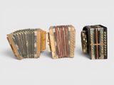 two old accordions sitting side by side on a white surface