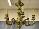 a gold chandelier with five candles hanging from it