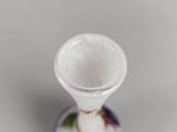 a small white vase with a floral design on it