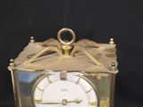 a gold clock that is sitting on a black table