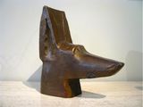 sculpture of a dog ' s head on a table with a white wall in the background