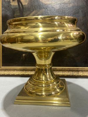 a gold plate on a pedestal with a picture in the background