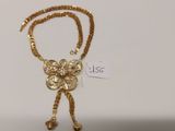 collier plaqué or présenté dans un écrin avec une étiquette de prix
