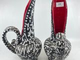 paire de vases en céramique représentant des éléphants, en noir et blanc, avec des pieds rouges
