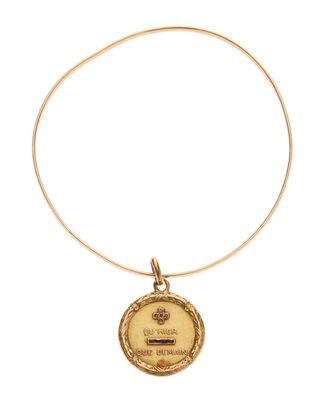 a close up of a gold necklace with a coin on it