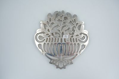 a silver broochee on the wall of a bathroom