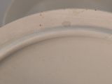 a close up of a white plate with a brown spot on it