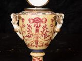 a vase that has a clock on top of it