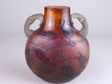 a glass vase with a handle on it on a table