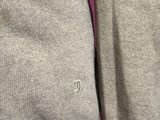 a close up of a person wearing a sweater with a button on it