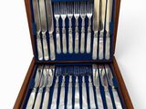 a wooden case with silverware in it on a white surface
